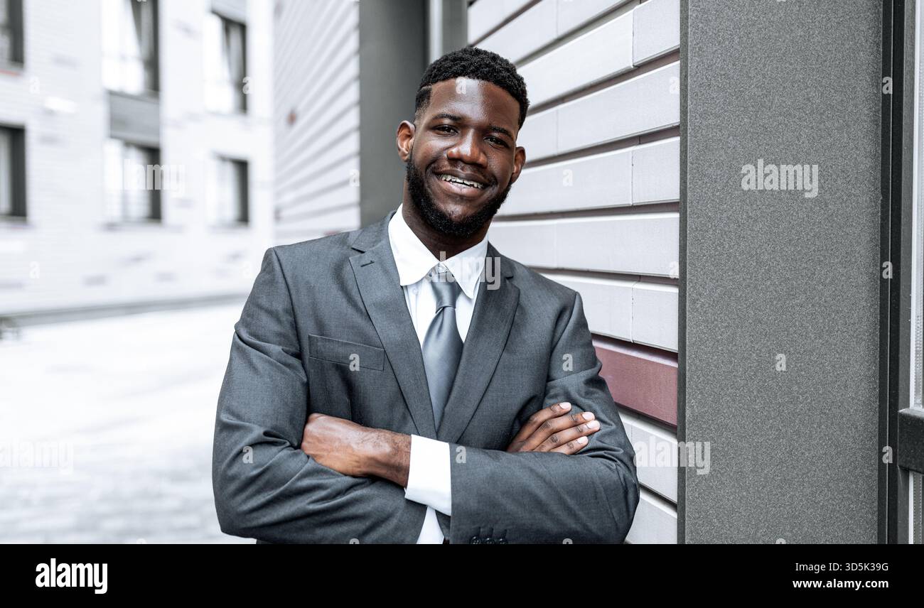 confident man in formal suit poses for a picture in a modern urban setting 3d5k39g